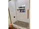 White tiled shower with glass door and built-in shower products niche at 3032 Morning Glory Ln, Vale, NC 28168