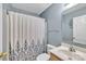 This bathroom has light blue walls, a white shower curtain, a toilet, and a wooden vanity at 306 Chinaberry Dr, China Grove, NC 28023