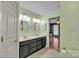 Bathroom with double vanity, mirrors, and access to the main bedroom at 306 Chinaberry Dr, China Grove, NC 28023
