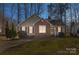 The home features a brick facade, green shutters, and a well-maintained lawn at twilight at 306 Chinaberry Dr, China Grove, NC 28023