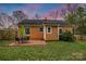 Backyard featuring a brick house, a stone patio with a table and chairs, and a grassy yard at 4010 Hiddenbrook Dr, Charlotte, NC 28205