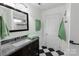 Updated bathroom with tiled shower, granite countertop, and black and white checkered floors at 4010 Hiddenbrook Dr, Charlotte, NC 28205