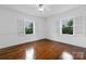 Inviting bedroom with hardwood floors, white walls, and bright windows with shuttered blinds at 4010 Hiddenbrook Dr, Charlotte, NC 28205