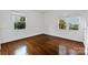 Bright bedroom featuring hardwood floors, white walls, and windows with tree views at 4010 Hiddenbrook Dr, Charlotte, NC 28205