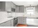 Close-up of the kitchen area with subway tile backsplash, quartz countertops, and a farmhouse sink at 4783 Rainey Ln, Maiden, NC 28650