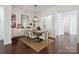 Formal dining room featuring hardwood floors, a decorative light fixture, and an adjacent butler's pantry and hallway at 4922 Looking Glass Trl, Denver, NC 28037