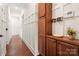 Hallway featuring dark hardwood floors, white paneled walls, and a wood storage cabinet at 4922 Looking Glass Trl, Denver, NC 28037