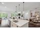 Bright kitchen island with marble countertops and stainless steel appliances with an open living area at 4922 Looking Glass Trl, Denver, NC 28037