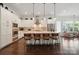 Bright eat-in kitchen with white cabinetry, stainless steel appliances and decorative pendant lighting over a quartz countertop island at 4922 Looking Glass Trl, Denver, NC 28037