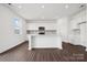 A modern kitchen with white cabinets, an island, quartz countertops, and stainless steel appliances at 557 Mountain View Dr, Monroe, NC 28110