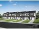 Row of new townhomes featuring modern architecture, individual garages, and manicured lawns at 7004 Matz Way, Charlotte, NC 28269