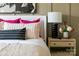 Close-up on bedroom details: pillows, nightstand, lamp, and floral arrangement enhance the inviting atmosphere at 7008 Matz Way, Charlotte, NC 28269