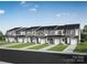 New townhome row showcases a modern design with neutral colors, individual garages, and well-manicured lawns at 7012 Matz Way, Charlotte, NC 28269