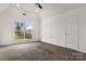 A bright bedroom with a vaulted ceiling and a large window looking out to the backyard at 7121 Lanark Ct, Charlotte, NC 28217