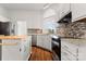 Modern kitchen with stainless appliances, a wooden island, and mosaic backsplash at 7121 Lanark Ct, Charlotte, NC 28217