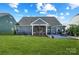 This beautiful backyard features a covered patio with seating, a well-manicured lawn, and ample space for outdoor activities at 7348 Adirondack Dr, Denver, NC 28037