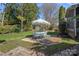 Backyard with green grass and a patio set under an umbrella next to a screened-in porch at 7824 Hickory Stick Pl, Charlotte, NC 28277