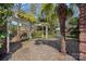 Backyard brick patio with a white pergola and plenty of green space and trees at 7824 Hickory Stick Pl, Charlotte, NC 28277