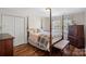 Bedroom with hardwood floors, a four poster bed, and a large window at 7824 Hickory Stick Pl, Charlotte, NC 28277