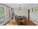 Bright dining room featuring hardwood floors, a modern chandelier, and natural light from the window at 7824 Hickory Stick Pl, Charlotte, NC 28277