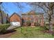 Charming two-story red brick home with a well-manicured lawn and blossoming trees at 7824 Hickory Stick Pl, Charlotte, NC 28277
