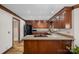 A well-designed kitchen features granite countertops, wood cabinets, a gas cooktop, and hardwood floors for an elegant feel at 7824 Hickory Stick Pl, Charlotte, NC 28277