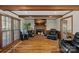 Inviting living room featuring a brick fireplace, hardwood floors, and natural light from the large window at 7824 Hickory Stick Pl, Charlotte, NC 28277
