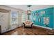 A cozy living room featuring hardwood floors, ample light, and a decorative blue accent wall at 7824 Hickory Stick Pl, Charlotte, NC 28277