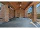 Covered outdoor patio with brick columns, multiple ceiling fans, and a charming water fountain at 7824 Hickory Stick Pl, Charlotte, NC 28277
