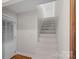 A bright staircase with carpeted steps and a white door is illuminated by natural light at 7824 Hickory Stick Pl, Charlotte, NC 28277