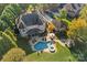 Stunning aerial view of a beautiful brick home with a private pool, patio, and lush green landscaping at 8724 Highgrove St, Charlotte, NC 28277