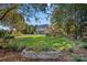 Lush backyard with a sprawling lawn, garden beds, and a large brick home in the background at 8724 Highgrove St, Charlotte, NC 28277