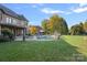 Luxurious backyard with a pool, fire pit, ample seating, and a well-manicured lawn at 8724 Highgrove St, Charlotte, NC 28277