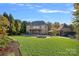 Expansive backyard with a pool, fire pit, patio dining set, and a meticulously maintained lawn at 8724 Highgrove St, Charlotte, NC 28277