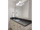 A well-lit bathroom features a vanity with granite countertops and a decorative framed mirror at 8724 Highgrove St, Charlotte, NC 28277