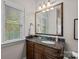 Bathroom with a granite countertop, framed mirror, and decorative accessories to add to the cozy aesthetic at 8724 Highgrove St, Charlotte, NC 28277