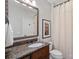 Bathroom featuring a dark wood vanity with a granite countertop and framed mirror for timeless sophistication at 8724 Highgrove St, Charlotte, NC 28277
