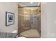 Shower with beige tile and a glass enclosure, a blend of traditional design and natural light at 8724 Highgrove St, Charlotte, NC 28277