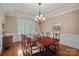 Formal dining room featuring a large table, elegant lighting, and plantation shutters for a bright atmosphere at 8724 Highgrove St, Charlotte, NC 28277