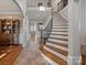 Grand foyer showcasing an elegant staircase with iron railings and tiled floor, setting a tone of sophistication at 8724 Highgrove St, Charlotte, NC 28277