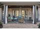 Charming covered patio with wicker furniture, ceiling fan, and classic brickwork; ideal for outdoor relaxation at 8724 Highgrove St, Charlotte, NC 28277