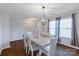 Formal dining room featuring hardwood floors, a contemporary light fixture, and backyard views at 10114 Turkey Point Dr, Charlotte, NC 28214