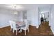 Formal dining room with hardwood floors, modern light fixture, and seating for six at 10114 Turkey Point Dr, Charlotte, NC 28214