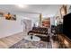 Cozy living room featuring a leather sofa, glass coffee table, and a seamless flow to the kitchen at 105 Abel Peterson Dr, Mount Holly, NC 28120
