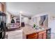 Open-concept living space with kitchen island, hardwood floors, and living room with cozy leather seating at 105 Abel Peterson Dr, Mount Holly, NC 28120