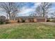 Charming brick ranch with a well-manicured lawn, mature trees, and attached garage at 107 Pinelake Dr, Kings Mountain, NC 28086