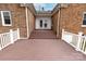 A back porch with steps leads to a red brick home with double doors at 10843 Caroline Acres Rd, Fort Mill, SC 29707