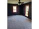 Bedroom features carpet, a ceiling fan, and two windows with views outside at 10843 Caroline Acres Rd, Fort Mill, SC 29707