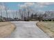 A long driveway leading to a house surrounded by bare trees and shrubbery at 10843 Caroline Acres Rd, Fort Mill, SC 29707