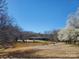 Scenic view of a pond with a brick home in the background on a clear day at 10843 Caroline Acres Rd, Fort Mill, SC 29707